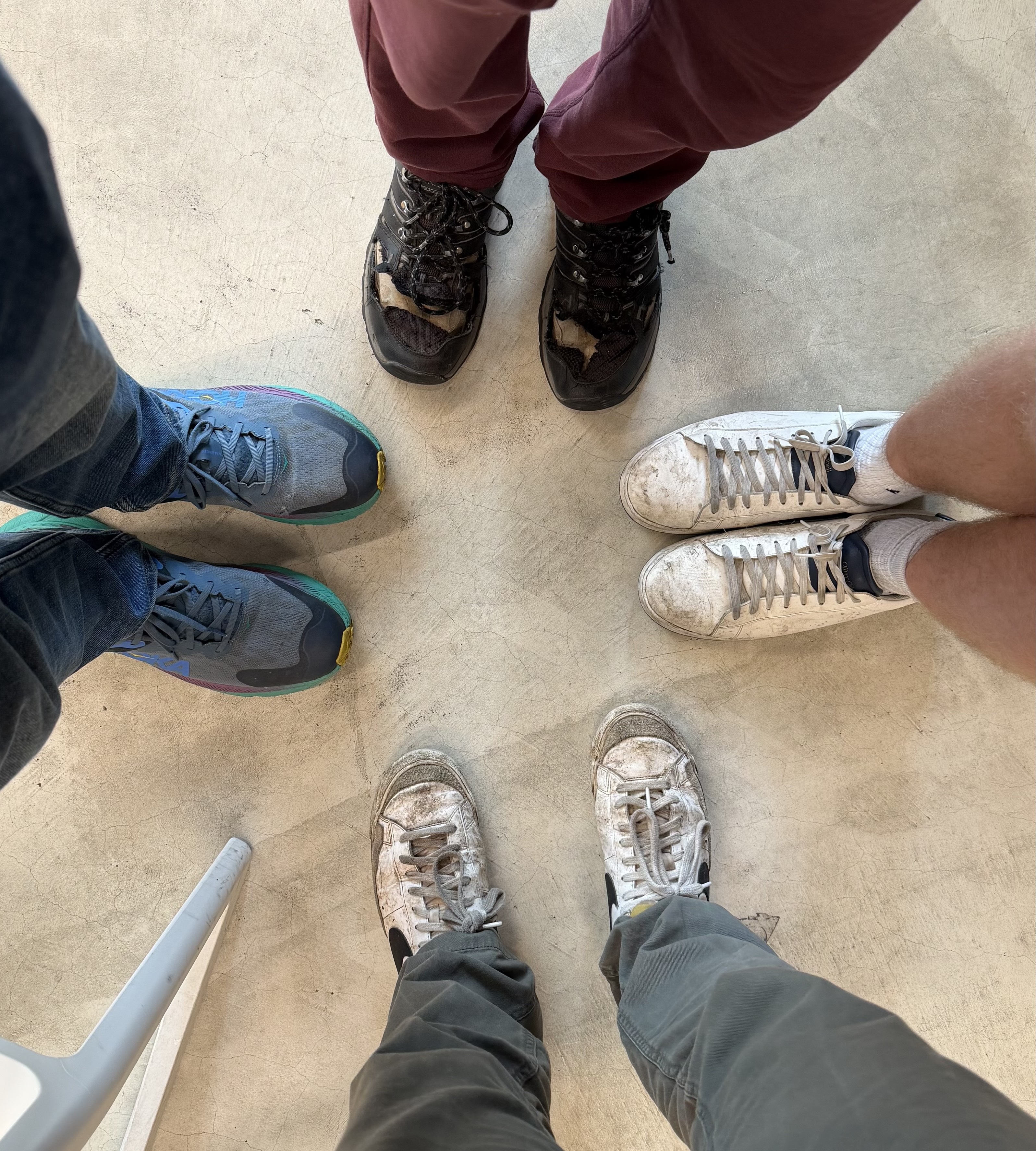 A group of people standing around wearing mostly white lace-up sneakers.